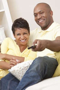 A couple laughing together while watching TV