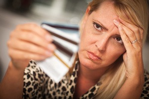 Upset Woman Glaring At Her Many Credit Cards.